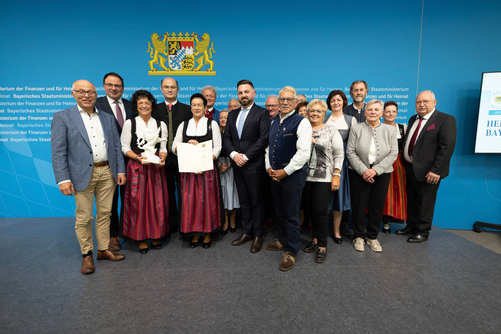 Stellvertretender Landrat Alfred Nickl, Zupfer-Moidln Waltraud und Renate, Bayerischer Staatsminister der Finanzen und Heimat Albert Füracker (hinter den Zupfer-Moidln), Erster Bürgermeister Sebastian Giering, sowie weitere Teilnehmende (v.l.n.r.) (Foto: Bayrisches Staatsministerium der Finanzen und für Heimat).